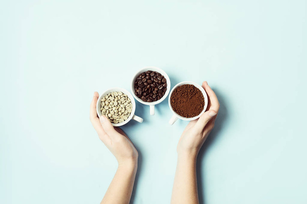 Different types of coffee - ground, grain and unroasted on blue pastel background - 写真・画像