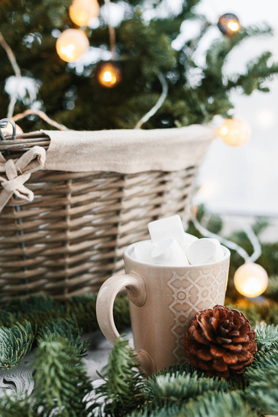 Spruce branches in basket and cup with cacao and marshmallow. Rustic new year christmas decoration at home, scandinavian interior - Valokuva, kuva