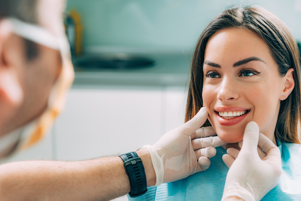 junge lächelnde Frau mit schönen Zähnen, bei einer zahnärztlichen Untersuchung - Foto, Bild