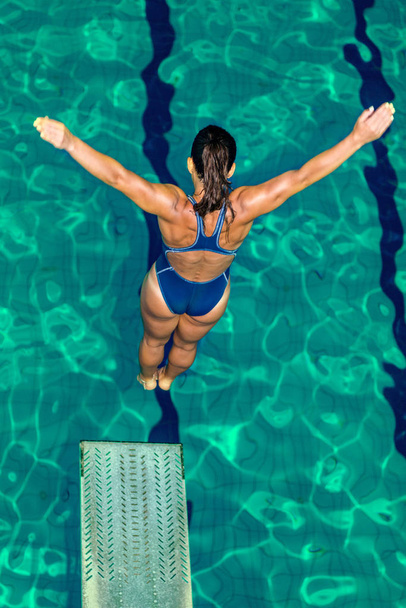 Ugrás a medencébe a trambulinról női búvár - Fotó, kép