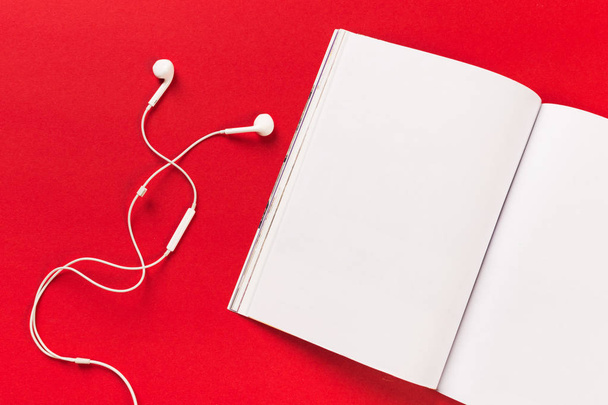 white headphones and a mocup magazine on a red background - Photo, image