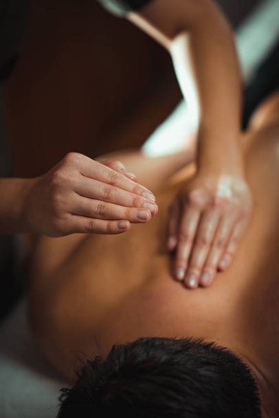 Physiotherapist massaging male patient with injured back muscle. Sports injury treatment. - Valokuva, kuva