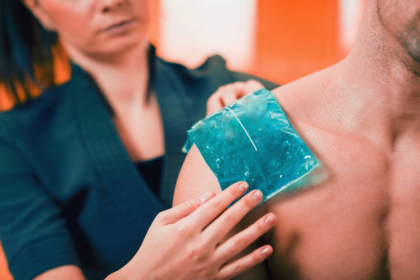 Holding the blue ice pack on the painful shoulder.  - Photo, Image