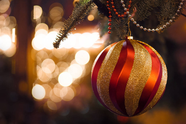 Big red gold ball in the foreground. Christmas background, Christmas decorations and garlands - Foto, imagen