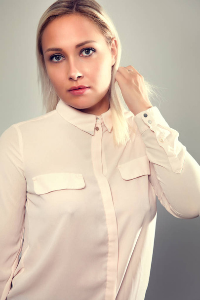 Beautiful female blonde model in shirt holding her hair - Foto, Imagem