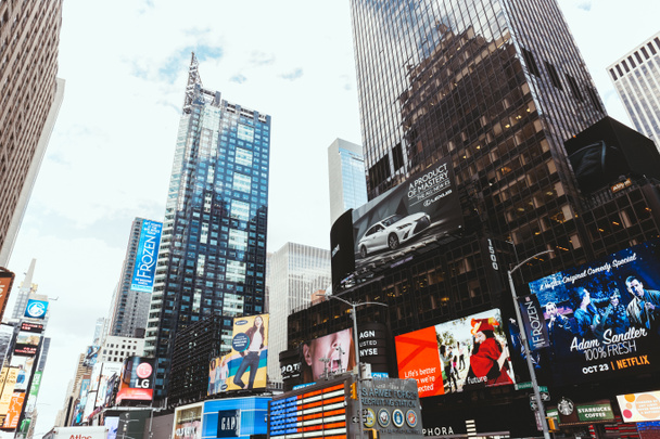 TIMES SQUARE, NEW YORK, USA - OCTOBER 8, 2018: low angle view of skyscrapers and billboards on times square in new york, usa - Zdjęcie, obraz