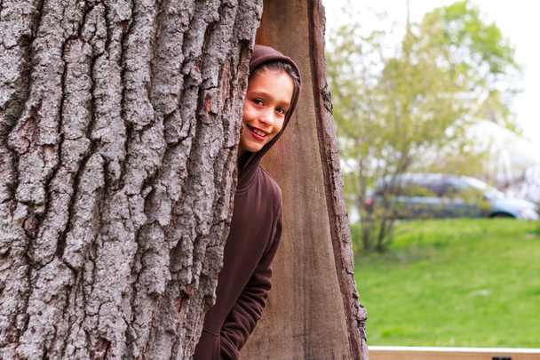 νεαρό κορίτσι κορυφώθηκε από ένα κοίλο δέντρο - Φωτογραφία, εικόνα