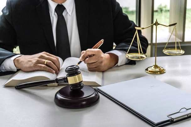 Law, lawyer attorney and justice concept, male lawyer or notary working on a documents and report of the important case in the workplace office. - Photo, Image