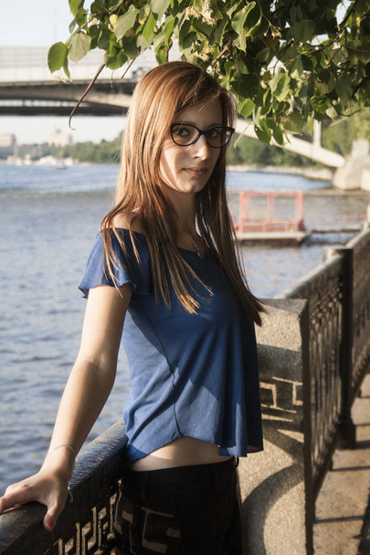 photo of a girl on the waterfront.background the city's waterfront - Zdjęcie, obraz
