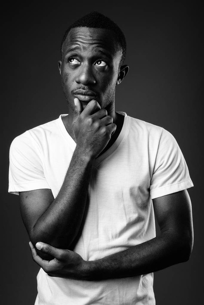Νεαρή Αφρικανή άνθρωπος ενάντια στη σκέψη σε μαύρο και άσπρο - Φωτογραφία, εικόνα