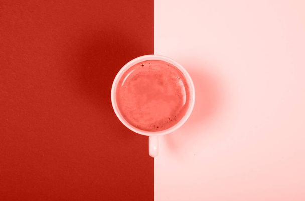 Красивая белая фарфоровая чашка кофе на фоне тонов цвета 2019 года. Живые кораллы
. - Фото, изображение