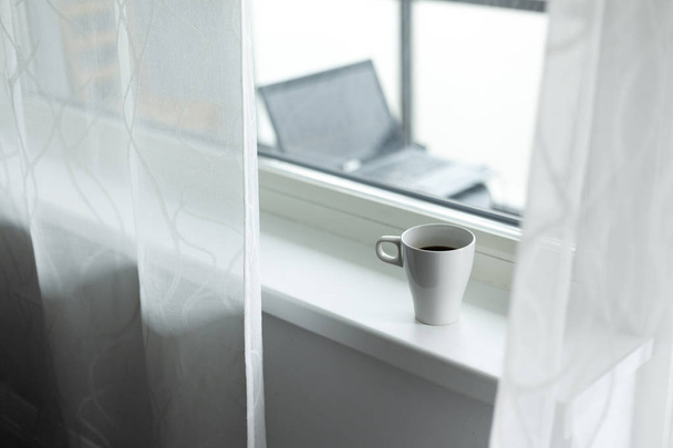 A cup of coffee on the windowsill. Big window. Scandinavian style. Copy space - Foto, immagini
