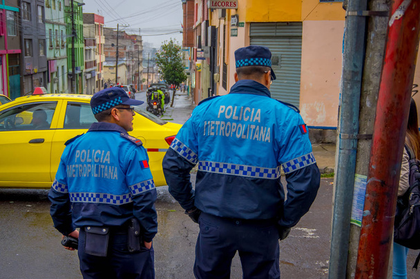 QUITO, ECUADOR - AUGUST 21, 2018: Outdoor view of Metropolitan policeman checking the safety of area before start the competition of racing a wooden car in the streets of city of Quito - Foto, immagini