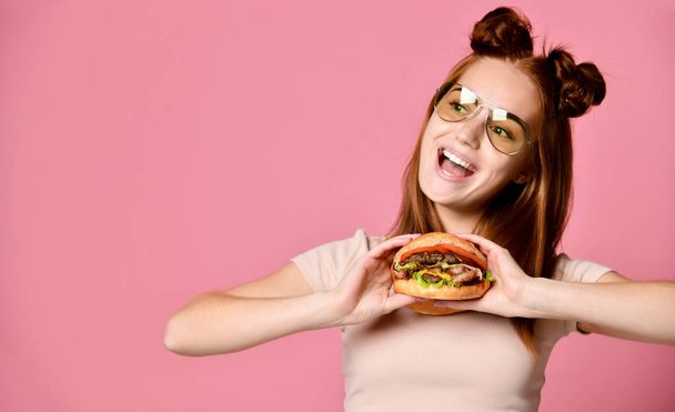 Close up portrait of a hungry young woman eating burger isolated over white background - Valokuva, kuva