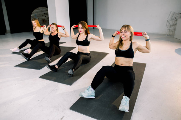 Portrait of happy female friends exercising with resistance bands in gym - Fotografie, Obrázek