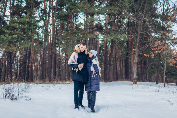 Beau couple amoureux marchant ensemble dans la forêt d'hiver. Des gens heureux qui s'amusent dehors
 - Photo, image