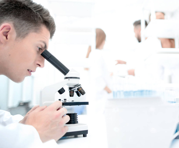 male research scientist looks at biological samples under micros - Fotó, kép