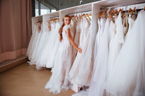 Female trying on wedding dress in a shop - Photo, Image