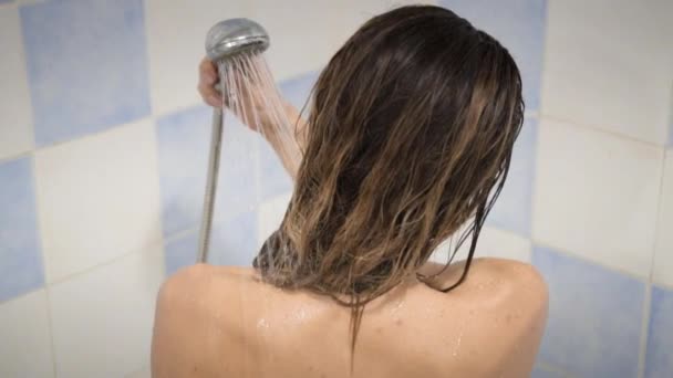 La femme prend une douche au ralenti, belle fille se lave et s'amuse sous une douche, près des mains, de l'épaule et du dos
 - Séquence, vidéo