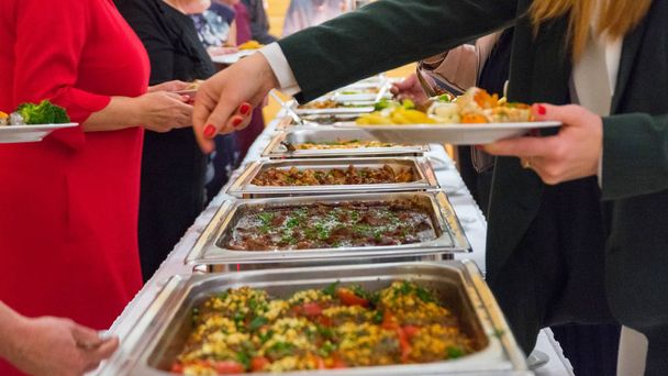 люди группы питание шведский стол питание в помещении в роскошном ресторане с мясом
 - Фото, изображение