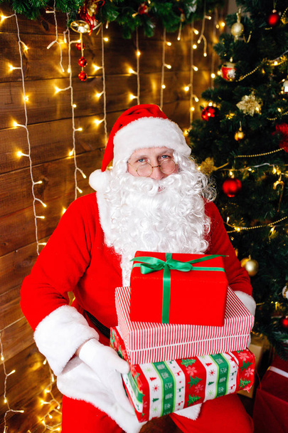 Merry Christmas. Santa Claus near Christmas tree with gifts - Foto, Imagen