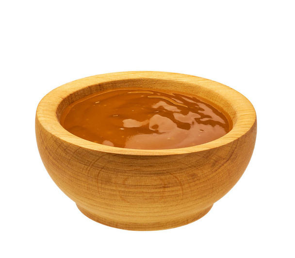 Cuenco de madera con salsa de naranja aislada sobre fondo blanco
 - Foto, imagen