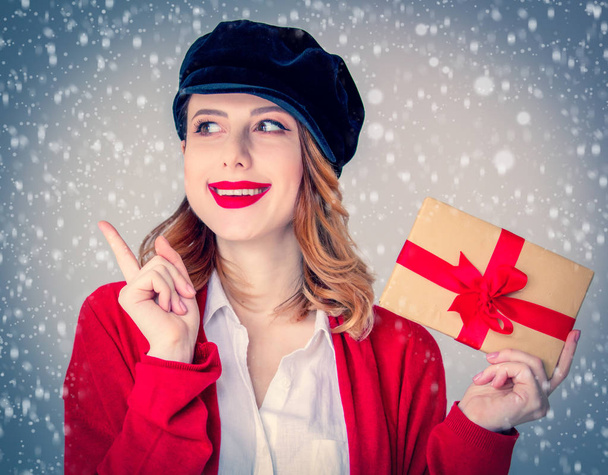 woman in red cardigan and hat with gift box - Photo, Image
