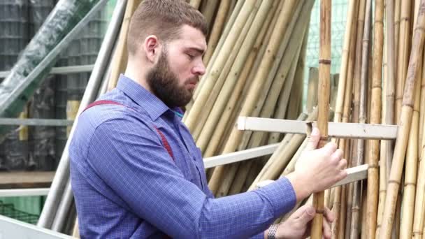 Człowiek w sklepu wybiera bambusowych mebli. - Materiał filmowy, wideo