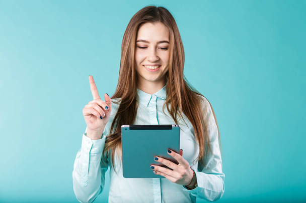 Portret młodego kaukaski kobieta długie włosy office koszulkę z tabletu w dłoniach trzyma kciuki, wykrzyknik, że to dobry pomysł. - Zdjęcie, obraz