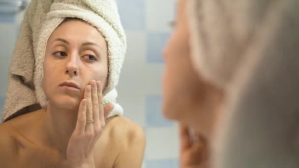 Meisje uitstrijkjes gezicht met een crème na badkamer. Huidverzorging - Video