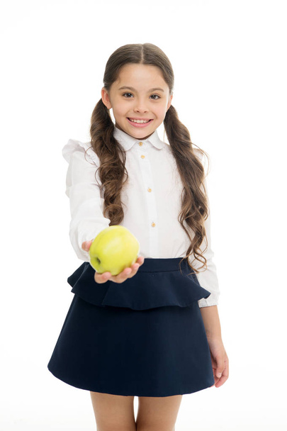 Girl cute pupil hold apple fruit stand on white background. Kid happy hold apple. School snack concept. Healthy nutrition diet. Apple vitamin snack. Child schoolgirl wear formal uniform hold apple - 写真・画像