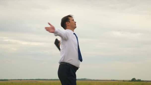 Businessman in white shirt and tie with briefcase in his hand whirlwind in flight against background of dark clouds - Footage, Video