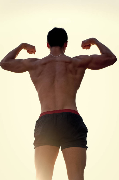 Man showing muscular body, back view - Zdjęcie, obraz