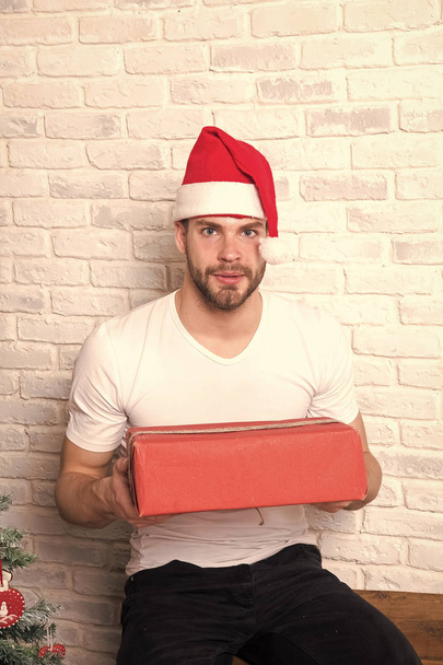 Man santa with box on white brick wall - Foto, Imagem