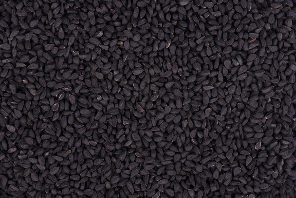 Black cumin seeds. Nigella sativa. Closeup background. - Фото, изображение