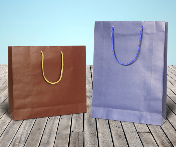 Bolsas de compras de papel de colores en suelo de madera
 - Foto, Imagen
