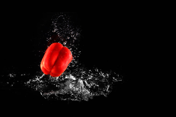 Fresh Red Bell Pepper with Water Splash and Bubble Isolated. Pepper Copy Space. Juicy Red Paprika Dropped Falling into Water on Black Background Great For Any Use. - Foto, Imagem