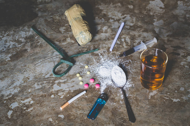 Drogas de diversos tipos en el suelo, Colección de diferentes drogas duras Heroína, Píldoras, Tabaco y alcohol, Concepto de adicción
 - Foto, Imagen
