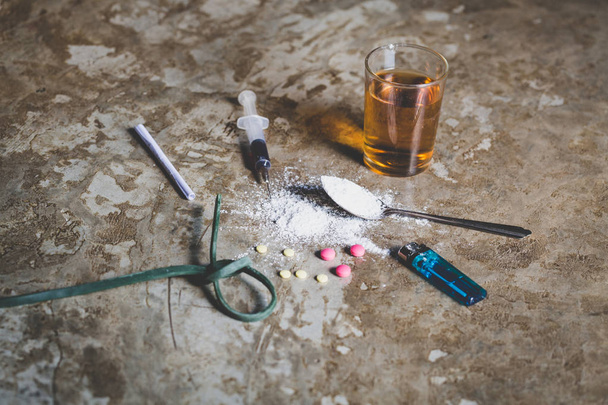 Drogas de vários tipos no chão, Coleção de diferentes drogas duras Heroína, Comprimidos, Tabaco e álcool, Conceito de dependência
 - Foto, Imagem
