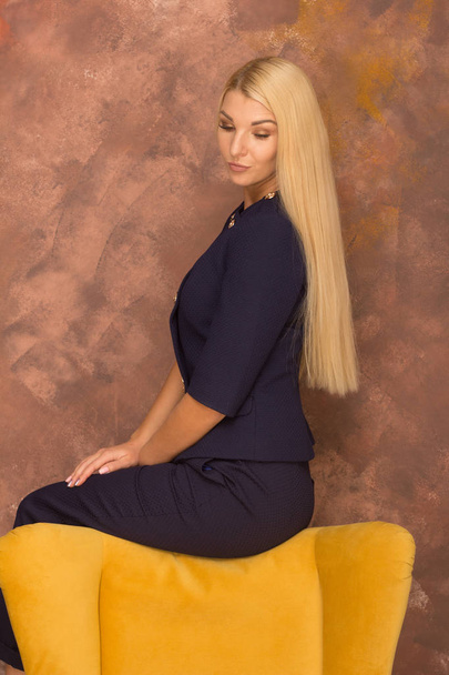 the photo of the girl in the background . photo shthe photo of the girl in the background . photo shoot on yellow chairoot on yellow chair - Фото, изображение