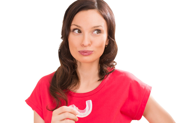 Woman wearing orthodontic braces holding silicone trainer - Valokuva, kuva