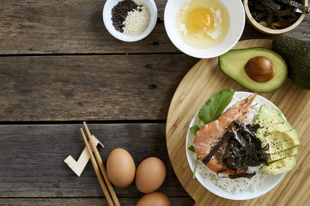 Poke ryżu Sashimi Krewetka miski z awokado czyste i zrównoważone zdrowe jedzenie concept.on ciemne drewniane tła, widok z góry - obraz - Zdjęcie, obraz