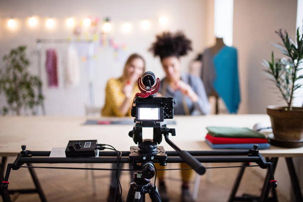 A camera and a slider with women in the background, startup business. - Фото, изображение