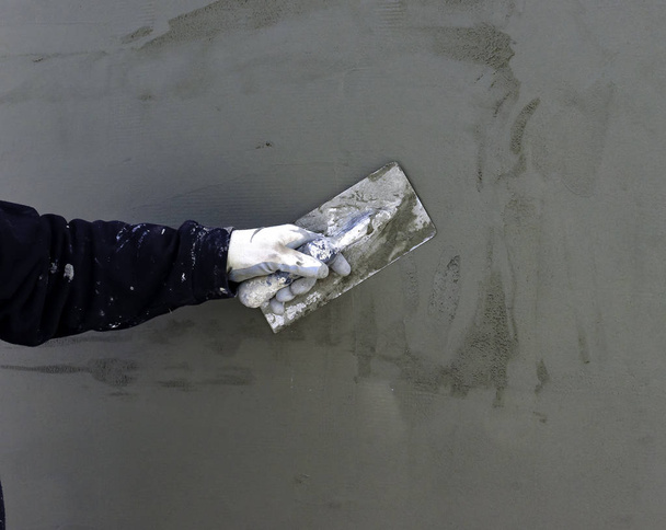 Arbeiter verputzen Werkzeugputz Marmor auf Innenputz grob. Selektiver Fokus - Foto, Bild