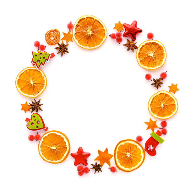 Cornice rotonda con arancio secco, decorazioni natalizie, stelle di anice su sfondo bianco. Posa piatta, vista dall'alto
 - Foto, immagini
