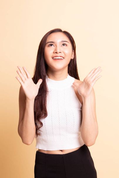 Young Asian woman is surprised and smile   on beige background - Foto, imagen