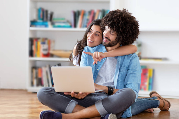 Young hipster couple with computer indoors at home - Foto, Bild