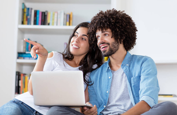 Happy hipster couple with computer indoors at home - Photo, Image