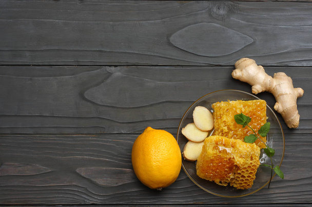 healthy background. honey, honeycomb, lemon, tea, ginger on dark wooden table. Top view with copy space - Zdjęcie, obraz