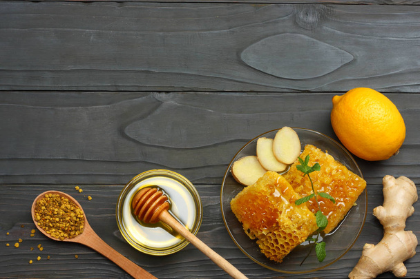 healthy background. honey, honeycomb, lemon, ginger on dark wooden table. Top view with copy space - Foto, Imagen